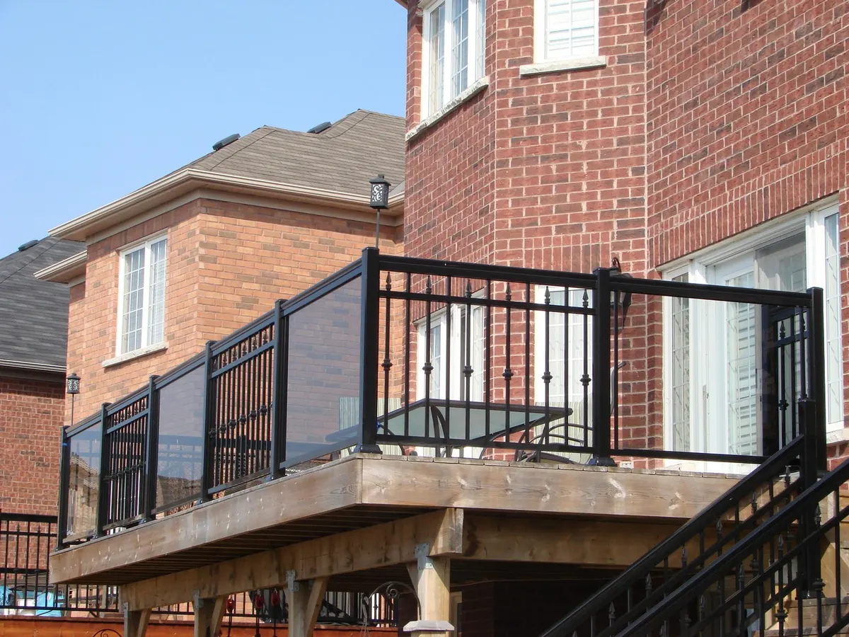 Black aluminum railing on raised second-floor deck with stair to grade