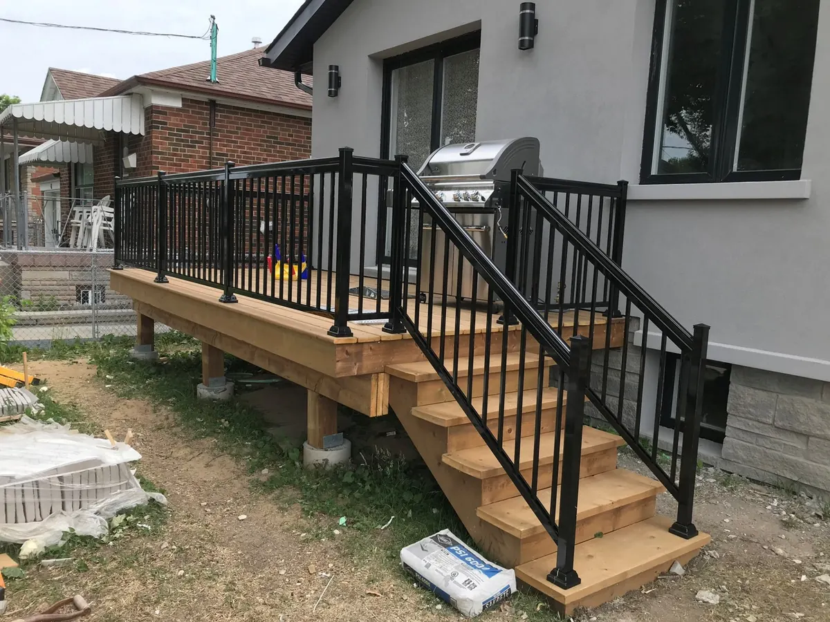 Black aluminum railing on freshly-built composite deck with stair