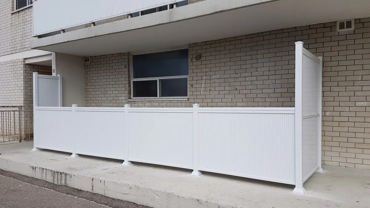 Frosted-glass privacy fence panels with white aluminum posts on side yard