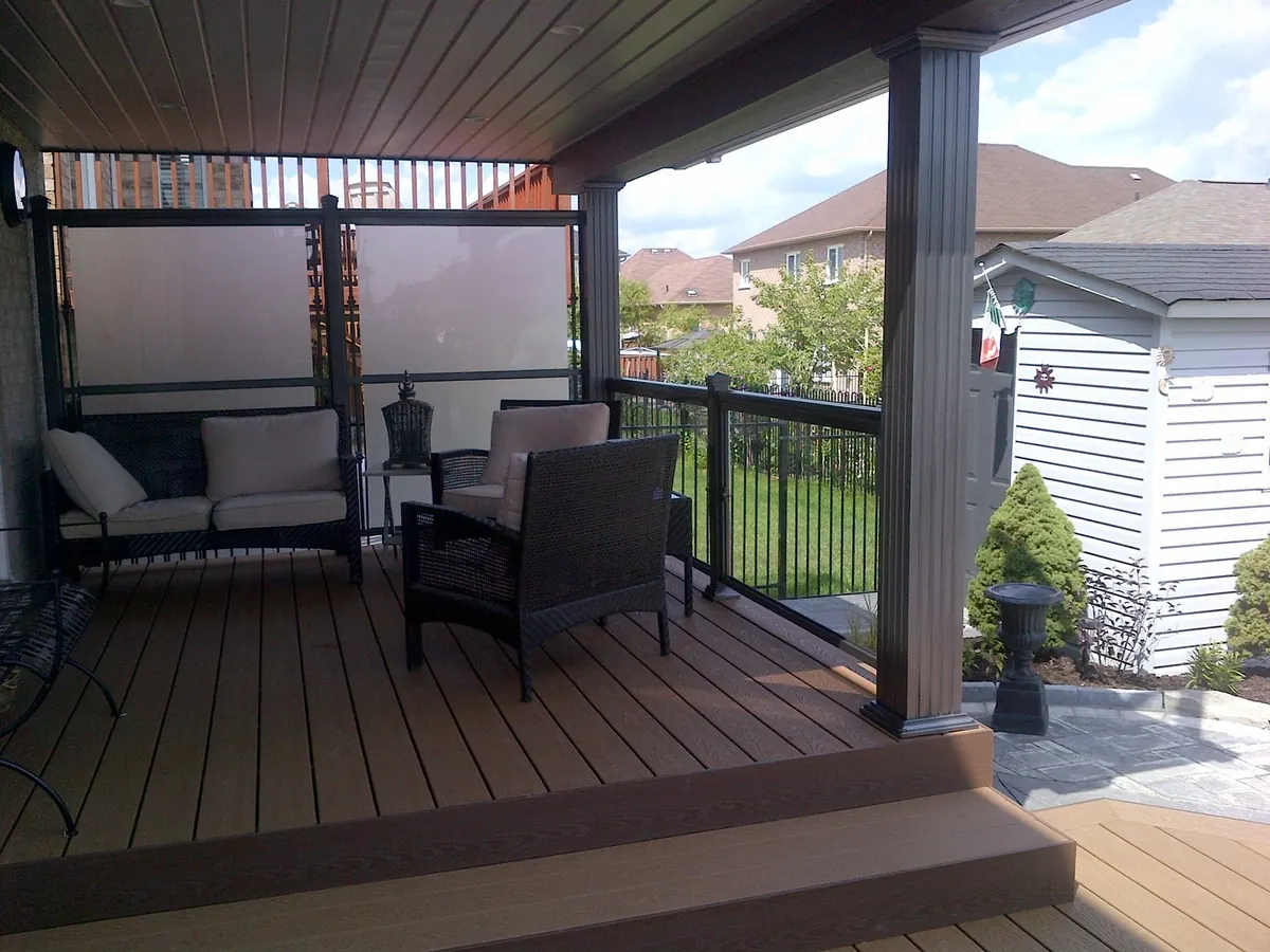 Glass railing along covered deck with seating area and outdoor furniture