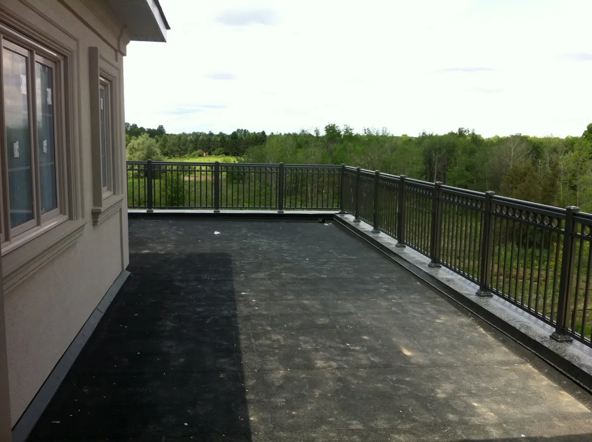 Black aluminum pool perimeter railing on freshly-resurfaced deck