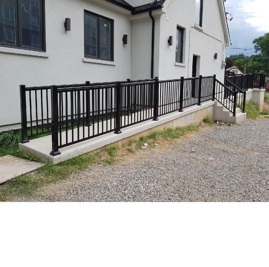 Black aluminum pool railing on accessibility ramp with gravel approach